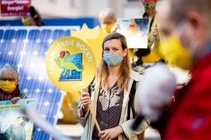 Frau mit Demo-Schild "Solarenergie rockt!"