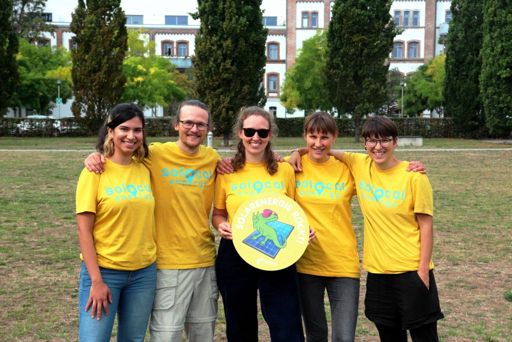 Das SoLocal Energy-Team in ihren knallgelben Shirts: Angélica, Arvid, Anni (die ein Schild mit "Solarenergie rockt!" hält), Anne und Kerstin