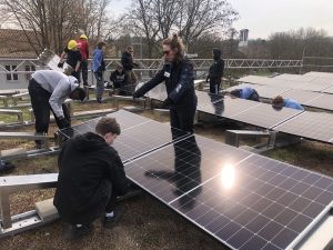 Menschen beim Aufbau einer PV-Anlage auf einem Schuldach
